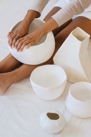 Hands holding handmade white ceramic bowls